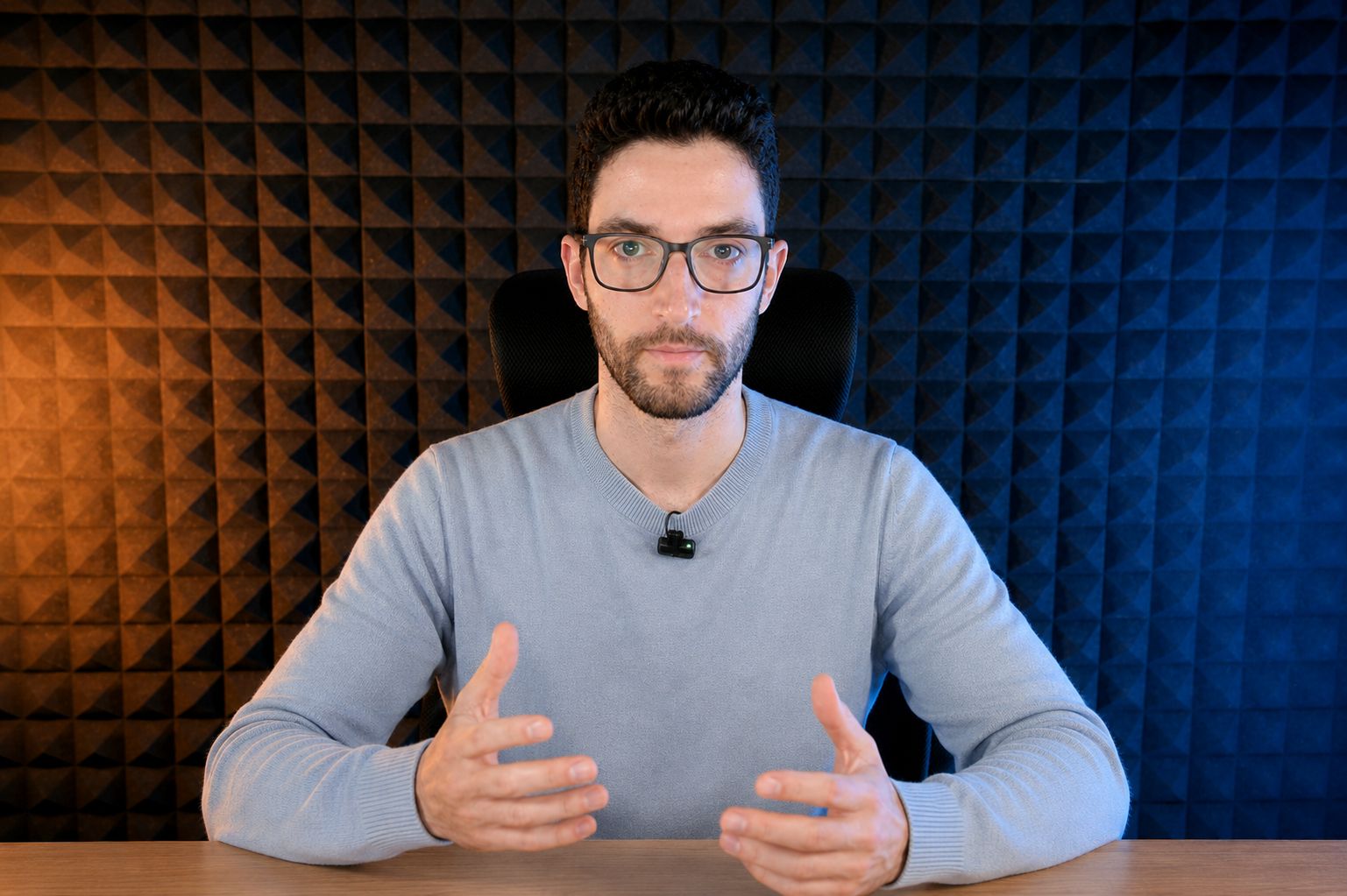 Raúl con gafas y micrófono impartiendo formación ante paneles acústicos.